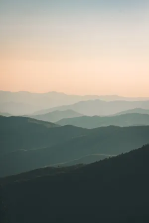 Layers of mountains extending to the horizon at dusk.