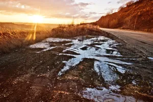 Muddy side of the road during sunset.