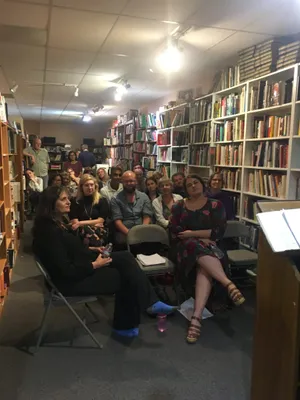 Small group at a poetry reading in a bookstore.