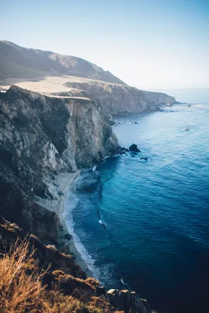 Mountain cliffs towering over ocean.